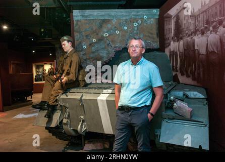 14 août 2023, République tchèque, Prag : l'historien tchèque Prokop Tomek se tient devant une maquette d'un char soviétique au Musée de l'Armée. Cette partie de l'exposition est consacrée à l'invasion de la Tchécoslovaquie par le Pacte de Varsovie le 21 août 1961. Lorsque les chars russes sont entrés en Ukraine le 24 février 2022, beaucoup de gens en République tchèque et en Slovaquie se sont sentis rappelés à une autre invasion : en août 1968, le Pacte de Varsovie, dirigé par l'Union soviétique, a écrasé le mouvement de réforme du Printemps de Prague dans ce qui était alors la Tchécoslovaquie. L'invasion, alors la plus grande opération militaire depuis la Seconde Guerre mondiale, a commencé exactement Banque D'Images