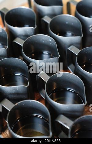Cire de bougie fondue assis dans des pots de coulée noirs Banque D'Images