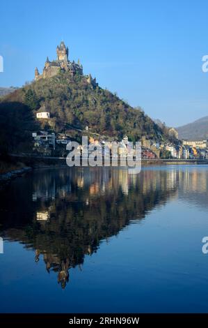 Château de Cochem ou Reichsburg Cochem avec ciel bleu reflété dans la rivière Moesel en hiver, Cochem, Allemagne. Banque D'Images