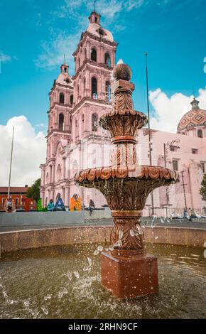 Fontaine dans le centre historique, avec une cathédrale d'un côté. Banque D'Images