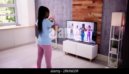 Jeune femme en condition physique vêtements faisant de l'exercice à la maison Banque D'Images