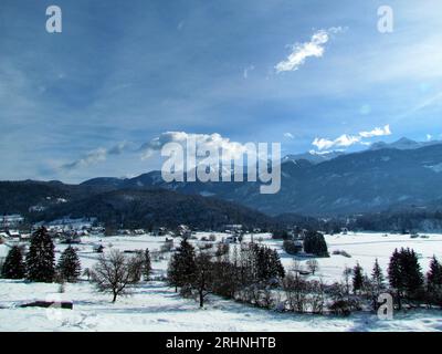 Vue du paysage rural près de Bohinj à Gorenjska, Slovenai et les montagnes dans les alpes juliennes derrière et le village de Stara Fuzina Banque D'Images