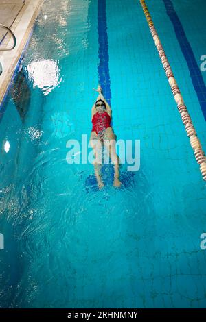 Nageur professionnel faisant de l'exercice sous-marin dans la piscine intérieure Banque D'Images