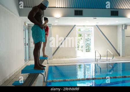 Deux nageurs se préparant à des plongées vers l'avant en piscine Banque D'Images