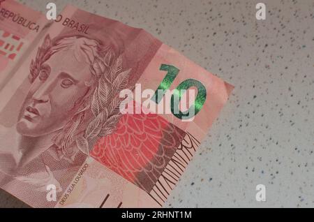 Détail du billet de banque de 10 reais do Brasil, une monnaie brésilienne mise en valeur par sa couleur rouge emblématique. Casa da Moeda do Brasil, représentant le B. Banque D'Images