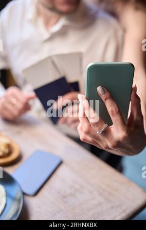 Couple de jeunes mariés faisant selfie tenant des billets et des passeports Banque D'Images