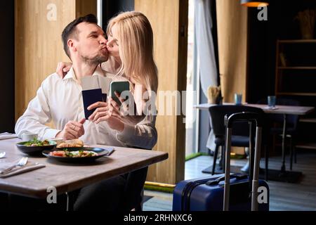 Beau couple s'embrassant tendrement tenant des passeports et des billets Banque D'Images