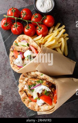 Deux pains pita enveloppés de viande et de légumes gros plan sur la planche sur la table. Vue verticale de dessus Banque D'Images