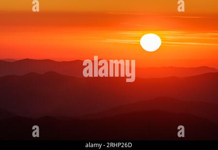 Coucher de soleil, parc national des Great Smoky Mountains - comté de Swain, Caroline du Nord. Le soleil se couche derrière les couches de crêtes de montagne visibles depuis Clingmans D. Banque D'Images