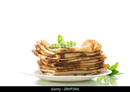 beaucoup de crêpes fines crêpes dans une assiette, isolée sur fond blanc. Banque D'Images