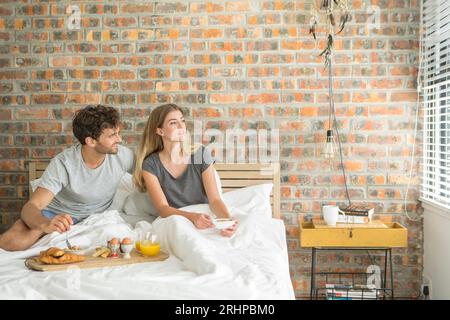 Couple having breakfast in bed Banque D'Images