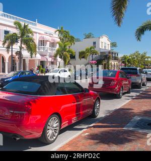 Naples, Floride, États-Unis. Voitures colorées garées dans la 3rd Street South bordée de palmiers, l'une des rues commerçantes les plus exclusives de la ville. Banque D'Images