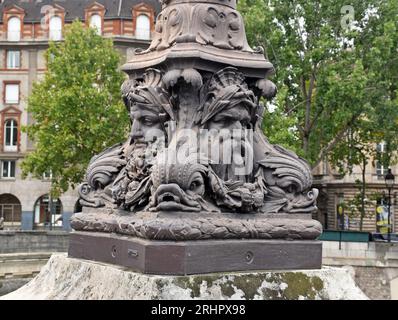 Socle de lampe sur le Pont neuf, le plus ancien pont de Paris, 1578-1607, avec mascarons et dauphins. Banque D'Images