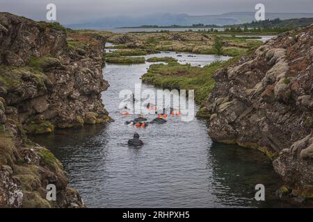 Sud-Ouest de l'Islande au début de l'été 2021, snorkelers dans Silfra fissure, spot de plongée et de plongée en apnée mondialement connu. Une crevasse longue d'un kilomètre dans le parc national islandais de pingvellir qui se jette dans pingvallavatn. La fissure a été formée par la dérive des plaques nord-américaine et eurasienne. Il s'élargit d'environ 7 mm chaque année. Banque D'Images