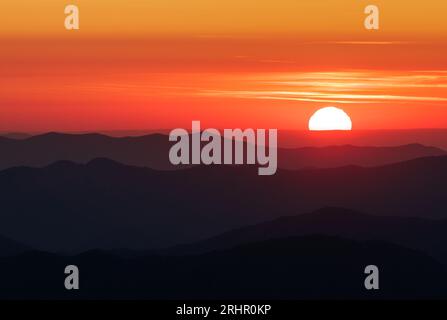 Coucher de soleil, parc national des Great Smoky Mountains - comté de Swain, Caroline du Nord. Le soleil se couche derrière les couches de crêtes de montagne visibles depuis Clingmans D. Banque D'Images