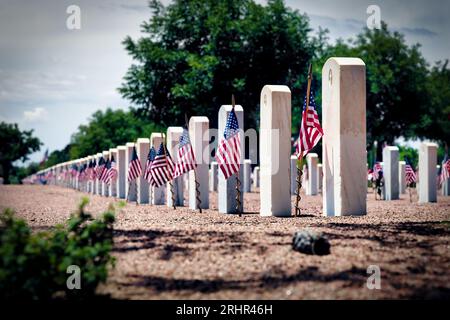 Un jour commémoratif ensoleillé avec des drapeaux flottant sur les tombes des militaires américains au cimetière national de fort Bliss à El Paso, Texas. Banque D'Images