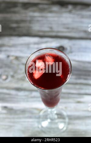 Verre à jus de Roselle frais réfrigéré fait à partir d'herbes de Roselle séchées bouillantes dans l'eau, un jus de bissap wonjo, fleurs de la plante Roselle Hibiscus, sw Banque D'Images