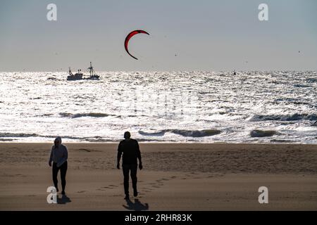 Kite surfeurs et bateaux crevettiers au large de Scheveningen, poussettes sur la plage, la Haye, pays-Bas Banque D'Images