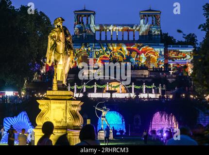 Potsdam, Allemagne. 18 août 2023. L'Orangerie illuminée en couleurs lors de la 25e nuit du Palais de Potsdam dans le parc de Sanssouci, qui a lieu les 18 et 19 août. Avec le titre 'prachtig' une touche néerlandaise a été donnée au programme. Un monde de conte de fées de danse, théâtre, musique, acrobaties, lectures, des installations lumineuses et des délices culinaires seront proposés dans le parc du palais de Sanssouci. Crédit : Jens Kalaene/dpa/Alamy Live News Banque D'Images