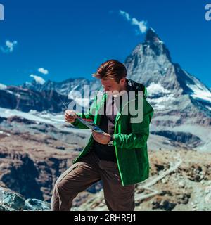 Touriste avec carte sur fond de montagne Matterhorn dans les Alpes suisses Banque D'Images