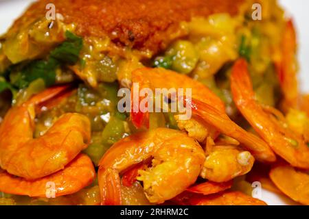 Typy Acaraje - boulette brésilienne traditionnelle à base de pois aux yeux noirs et d'oignons farcis de vatapa, de caruru, de salade de tomates et de crevettes. Banque D'Images