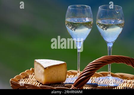 Fromage et vin, Roussette de Savoie blanc sec ou vin de Savoie de la région savoyarde avec fromage de tomme servi sur la frontière du col du Galibier région savoyarde Banque D'Images