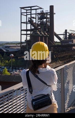 Une femme sur le Skywalk photographie le haut fourneau de l'usine industrielle Phoenix-West, Allemagne, Rhénanie du Nord-Westphalie, région de la Ruhr, Dortmund Banque D'Images