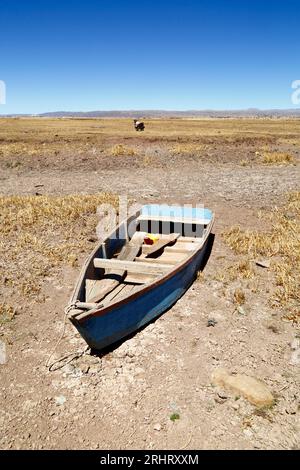 Lac Titicaca, BOLIVIE ; 18 août 2023 : bateau à rames en bois sur la rive asséchée de la baie de Cohana sur le lac intérieur / Huiñay Marka (la plus petite partie du lac Titicaca) près du village de Cohana. Les niveaux d'eau dans le lac Titicaca approchent du niveau record établi en 1996, le plus bas depuis que le service météorologique bolivien (Senhami) a commencé à tenir des registres en 1974. Beaucoup blâment le changement climatique ; les dernières années ont été plus sèches que la normale et El Niño se renforce actuellement dans l’océan Pacifique au large de l’Amérique du Sud. Banque D'Images