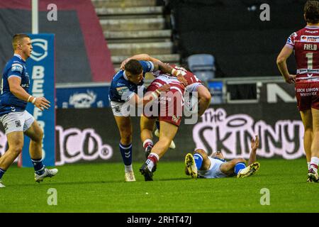 Liam Byrne des guerriers est attaqué par la défense du Hull FC lors du match de Betfred Super League entre Wigan Warriors et le Hull football Club au DW Stadium, Wigan, le vendredi 18 août 2023. (Photo : Ian Charles | MI News) Banque D'Images