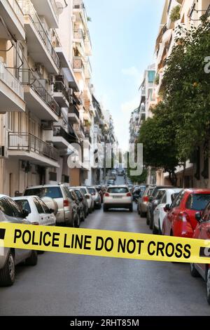 Ruban jaune de scène de crime bloquant le chemin dans la rue Banque D'Images