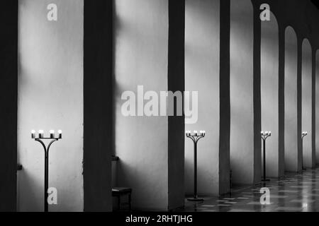 Ton noir et blanc, perspective intérieure diminuant, rangée de colonnes verticales et fenêtres de cadre d'arche le long du couloir ou couloir de vintage européen b Banque D'Images