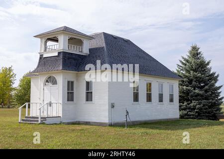 Vue ensoleillée du paysage d'une école rurale en bois du 19e siècle construite d'une pièce située sur une prairie dans le midwest des États-Unis. Banque D'Images