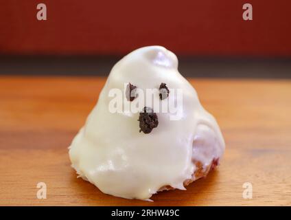 Croissants glacés de sucre blanc en forme de fantôme isolés sur fond de bois Banque D'Images