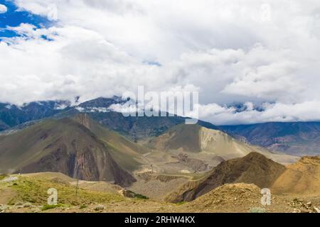 Paysage sombre et dramatique du désert avec montagnes Foggy et maisons lointaines à Muktinath, Mustang, Népal Banque D'Images