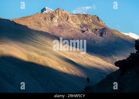 Trekker silhouette dans la lumière de fin d'après-midi, Panikhar, Zanskar, Inde Banque D'Images