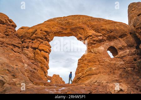 personne debout sous une arche dans le parc national des arches Banque D'Images