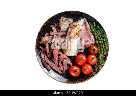 Côtelettes de bœuf fumées et grillées dans une assiette rustique aux herbes. Arrière-plan noir. Vue de dessus. Banque D'Images