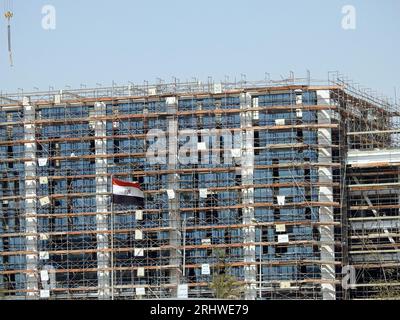 Le Caire, Egypte, juillet 21 2023 : un chantier de construction d'un nouveau bâtiment industriel avec échafaudages et grues par Hassan Allam construction avec l'ondulation Banque D'Images