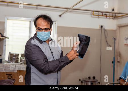 Un médecin regarde une radiographie d'un patient Banque D'Images