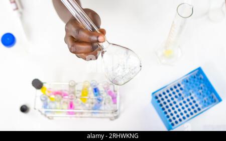 Gros plan des mains féminines tenant un erlenmeyer avec des échantillons de bulles à l'intérieur Banque D'Images