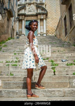 Jeune femme posant pour une photo dans un bâtiment emblématique à Gérone en Espagne Banque D'Images