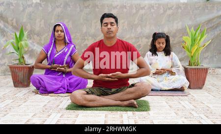 Concept de yoga, jeune indien en bonne santé s'exerçant à la maison, assis sur un tapis de sport, méditant Banque D'Images