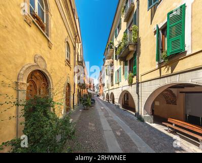 Cuneo, Piémont, Italie - 16 août 2022 : Contrada Mondovì, ancienne rue pavée avec arcade sous de vieux bâtiments colorés dans le centre historique Banque D'Images