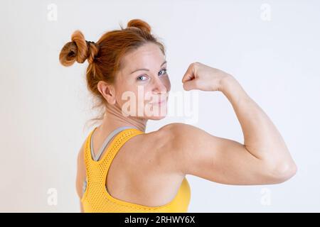 Jeune, blonde, femme en forme montrant ses muscles Banque D'Images