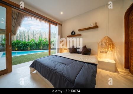 Décoration intérieure d'une chambre luxueuse et moderne, villa avec piscine, vue sur la piscine, jardin vert, transat ou transat sur la terrasse de la piscine, coussin bleu Banque D'Images