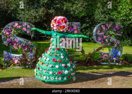 Un greeter portant une coiffe florale ornée de fleurs. Un festival lumineux et coloré de 2023 dans le nord-ouest les visiteurs sont accueillis au spectacle botanique par des marcheurs sur pilotis floraux à leur arrivée pour les quatre jours des magnifiques expositions de fleurs. Southport Merseyside, Royaume-Uni Banque D'Images