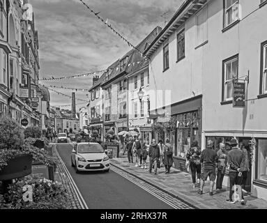 L'image monochrome de Flower Tubs et de Bunting apporte une sensation festive à Southside Street sur la Barbican historique de Plymouth. Un mélange original de petites boutiques, Banque D'Images