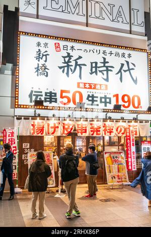 Des Japonais attendent devant l'entrée du restaurant Shin Jidai kushi katsu pour s'asseoir le soir dans la rue commerçante Shimotori, Kumamoto. Banque D'Images