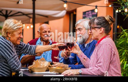 Les couples âgés mangent et boivent ensemble - les vieux amis ont une réunion dans un restaurant Banque D'Images