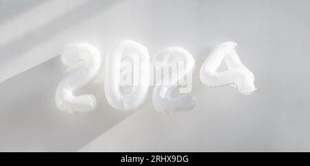 Nouvel an 2024. Fond festif monochrome avec numéros de ballons en aluminium. Banque D'Images